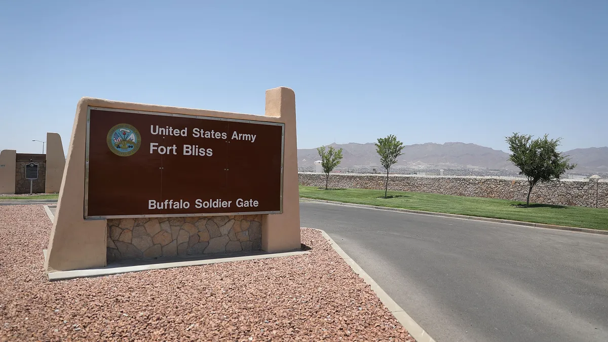 A road next to a sign reading &quot;United States Army Fort Bliss Buffalo Soldier Gate.&quot;