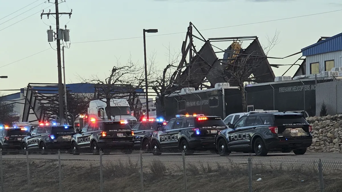 Police vehicles block off a collapsed structure.