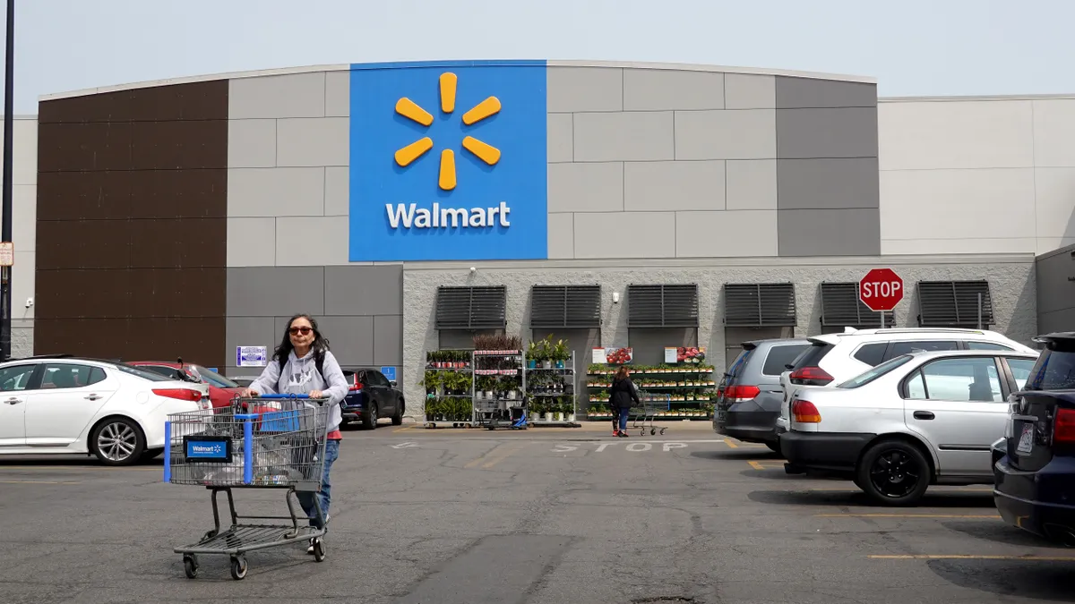 A person pushes a cart in front of Walmart